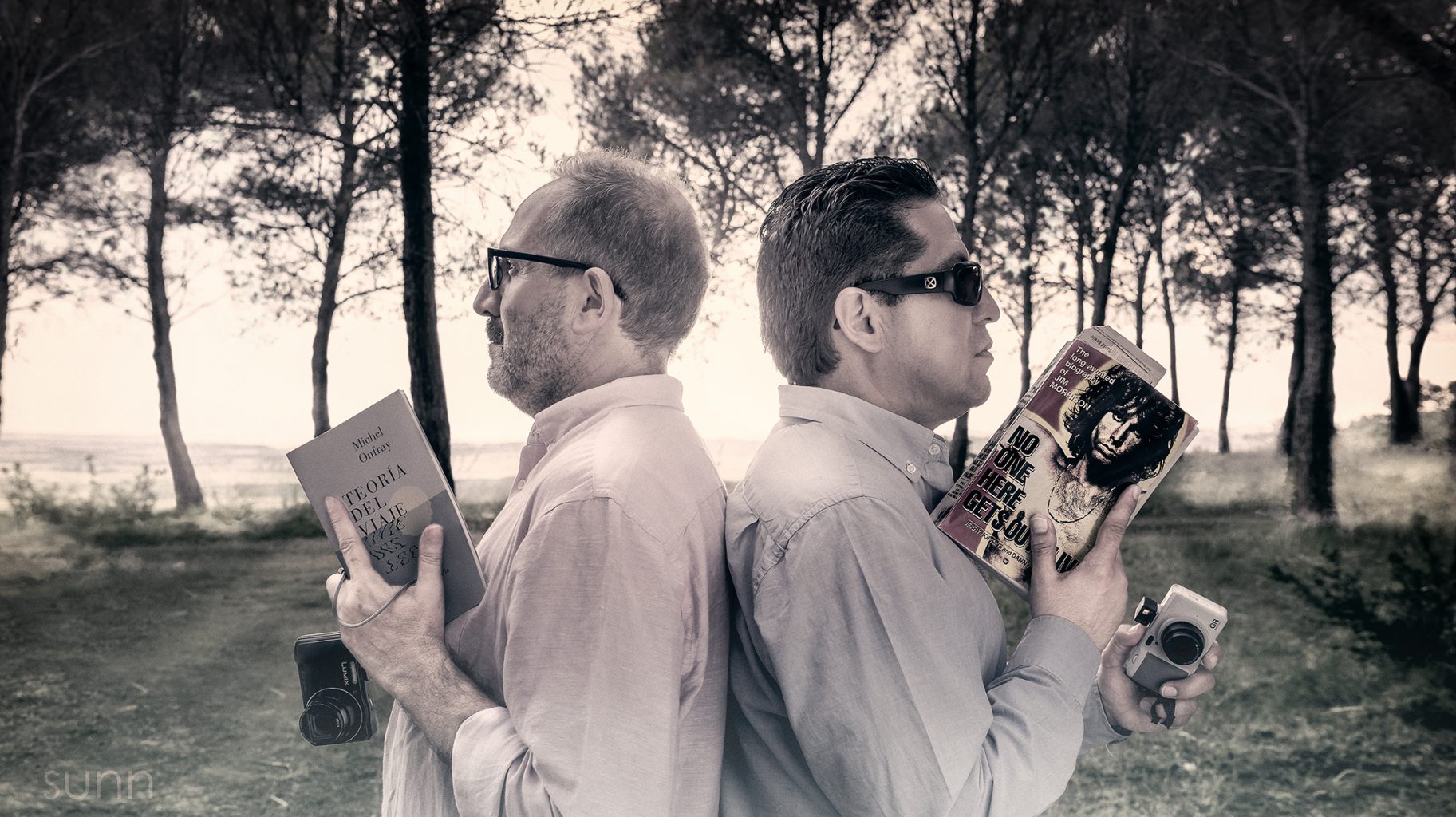 Vemos a dos personas espalda contra espalda simulando un duelo clásico entre caballeros,pero este es un duelo de cultura e imagen en lugar de pistolas. Van armados con cámaras fotográficas y un libro.